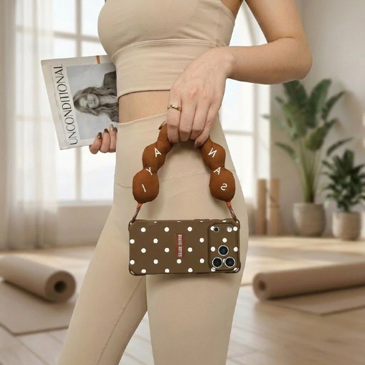 brown polka dot phone case with wrist strap – handbag carry lifestyle