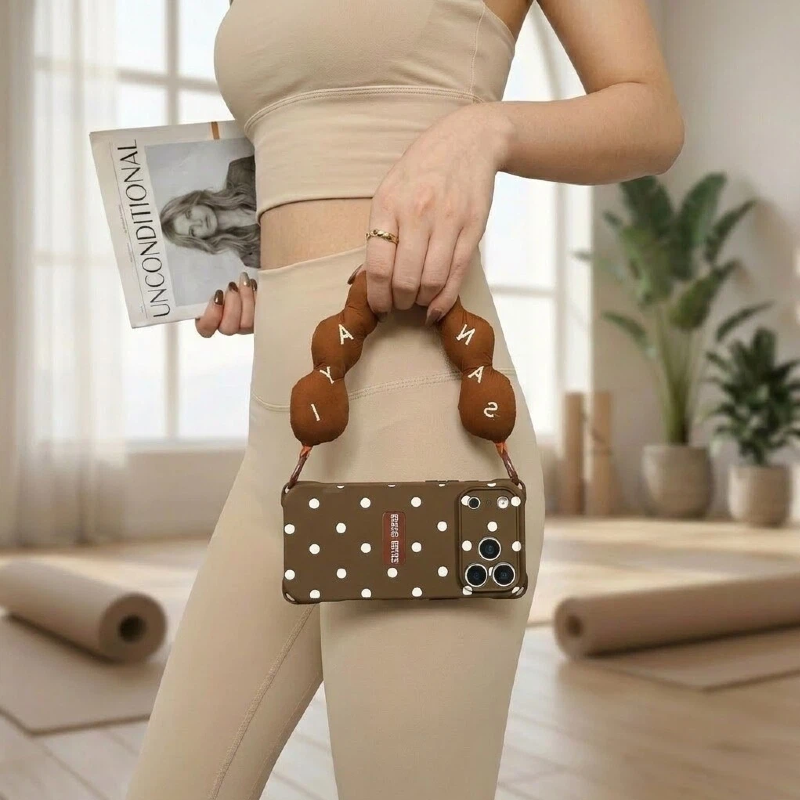 brown polka dot phone case with wrist strap – handbag carry lifestyle