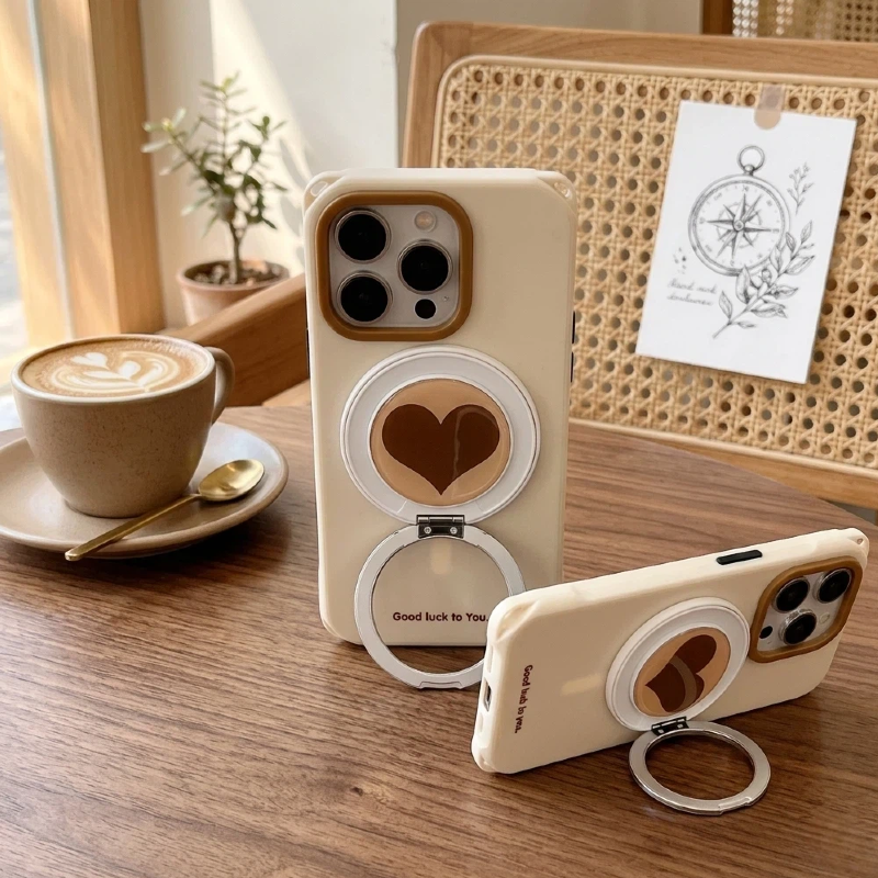 Flat lay of a sand-colored iPhone case featuring a built-in stand, coffee bean magnetic ring, and artisanal lanyard accessories on a neutral background.